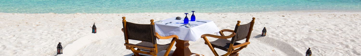 Romantic lunch setup on Maldivian beach in front of turquoise waters