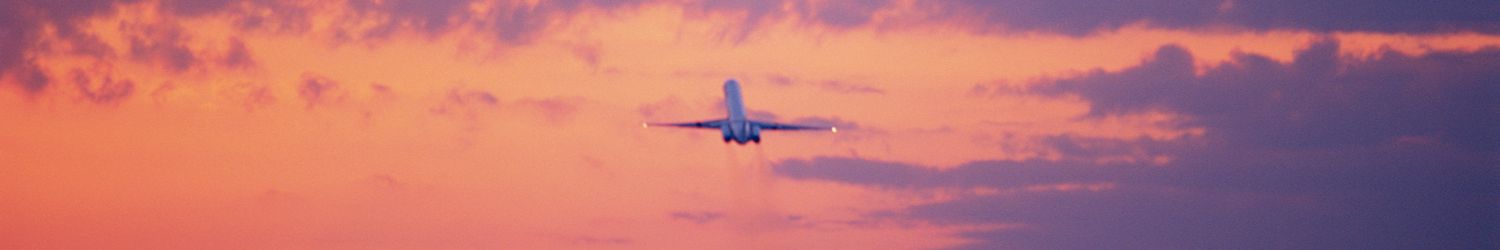 Commercial aircraft taking off, sunset, rear view