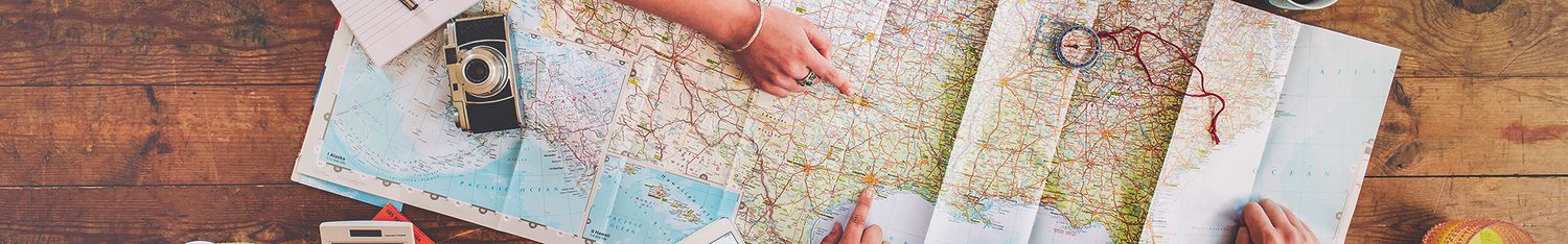 Women planning trip with map on wooden table