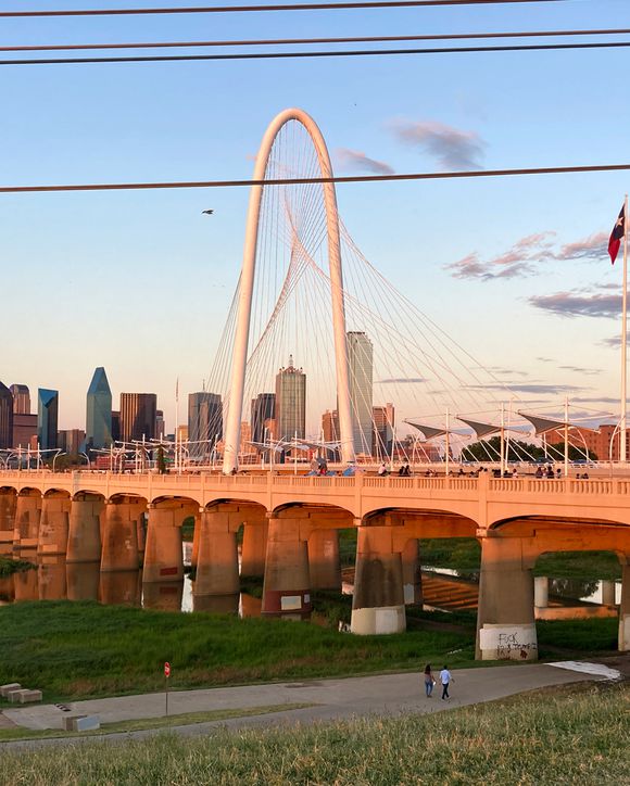 Sunset view of downtown Dallas and Margaret Hunt Hill bridge with the Ron C. Kirk Pedestrian bridge over the Trinity River.