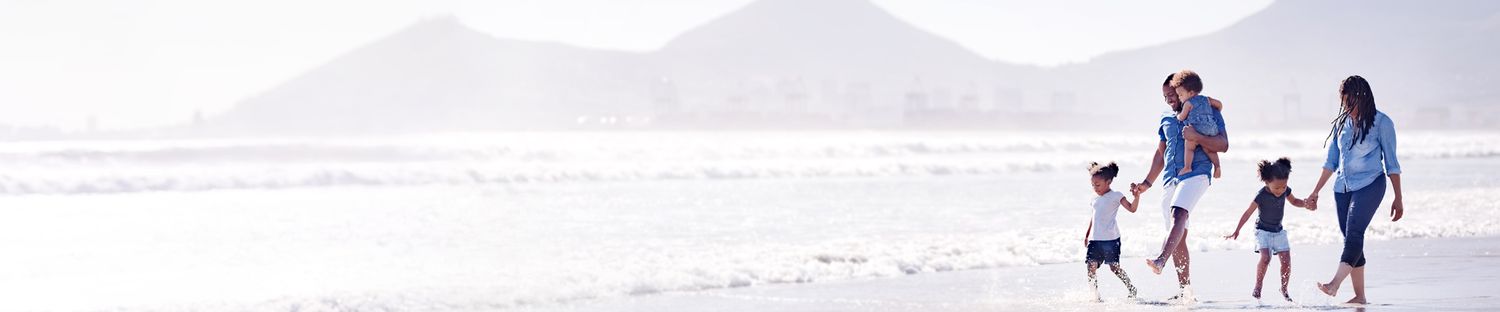 Shot of a young african family walking together in water at the beach