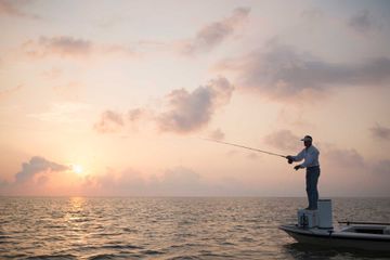 Caucasian man fishing on boat in ocean