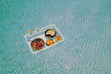 A Breakfast tray floats across a pool