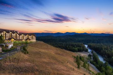 Exterior of Suncadia while sun sets behind trees and mountains