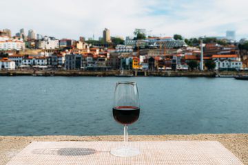 Glass of red Port wine overlooking Vila Nova de Gaia, Porto, Portugal