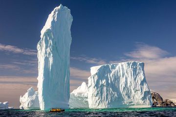 Ice Monolith with group of people in raft, Antarctica