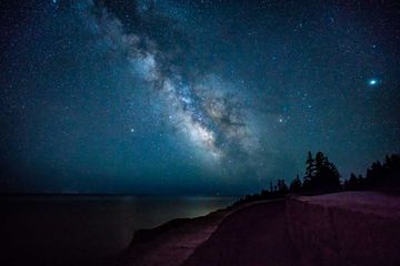 Milky Way and stars shine off the coast of Acadia National Park
