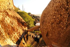 People dine below large rocks in the town on Monsanto, Portugal