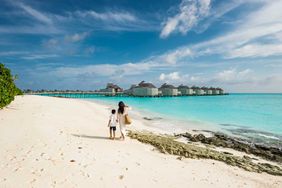 Mother and her son playing on the beach in Maldives island resort.