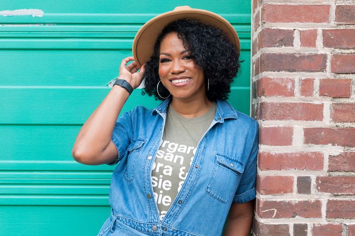 A portrait of Nicka Smith who is smiling and wearing a hat