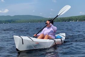 Person Kayaking in the Oru Kayak with mountains in the background