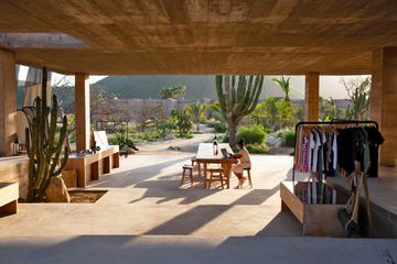 A woman sits at a table in an open-air common space at a luxury hotel in Mexico