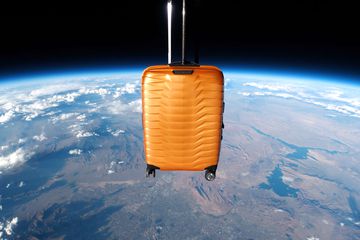 The Samsonite Proxis suitcase flies over Earth in outer space. 