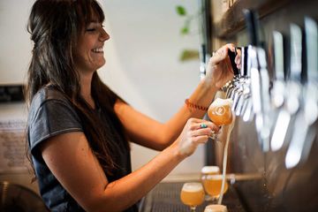 A bartender pulling beer at Pure Brewing in San Diego