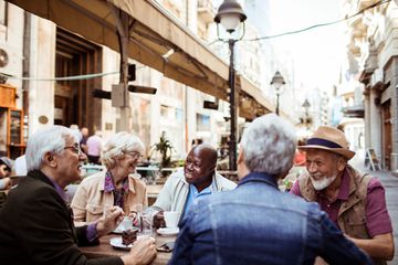 Group of seniors relaxing in a cafe after exploring a city.