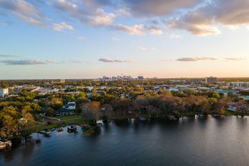 Aerial shot of trees, lake, and far off Downtown Orlando