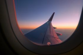 View through airplane window during flight at sunset