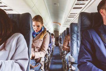 Interior of airplane with people sitting on seats. Passengers on seat during flight.