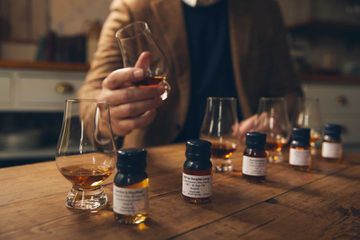 Mini bottles of scotch on a wooden table during a tasting session