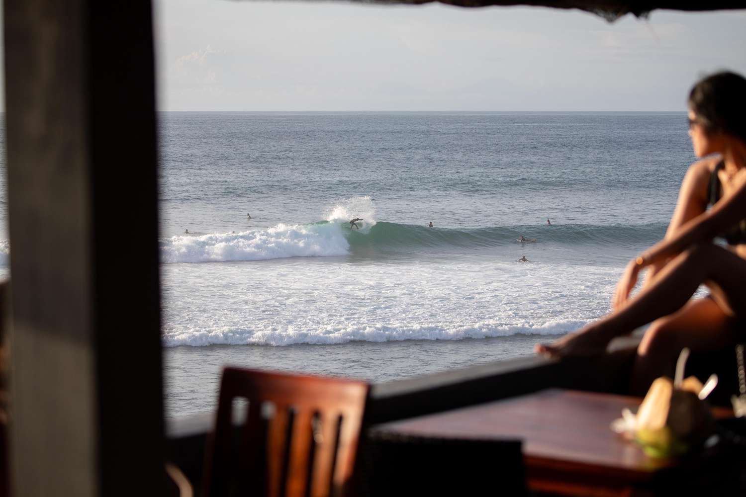 A woman overlooking surfers in Bali