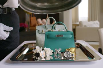 Birkin bags and watches on a room service platter 