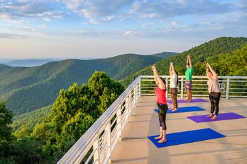 A group doing yoga on a rooftop overlooking mountains