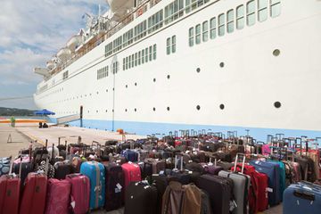 Luggage besides a docked cruised ship