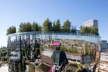  the mirrored façade of the Depot Boijmans Van Beuningen in Rotterdam, reflecting the city's skyline
