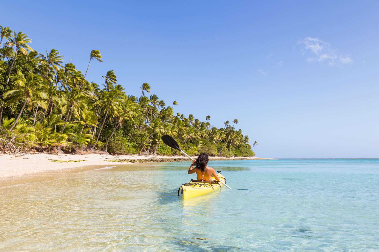 Woman on kayak near beach in a tropical island, Fiji 