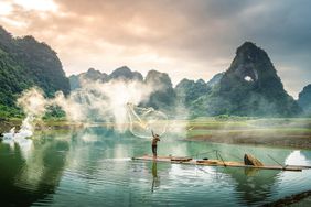 view of fishermen fishing on river in Thung mountain in Tra Linh, Cao Bang province, Vietnam with lake, cloudy, nature. Travel and landscape concept.