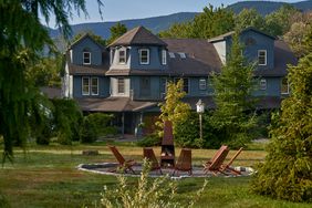 The back facade of Hotel Lilien with chairs around a fire pit 