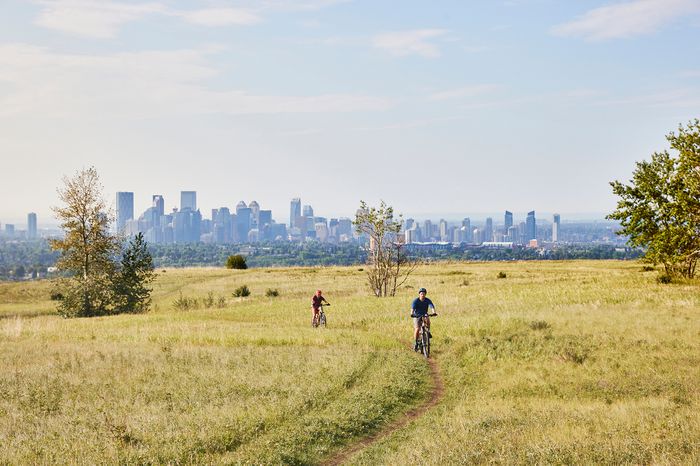 Two people riding bikes in Nose Hill Park in Calgary, Canada 