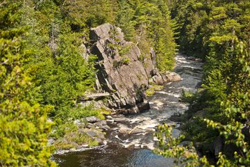 The Pleasant River plunges in a waterfall through a rock strewn gorge.