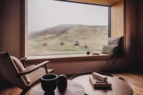 A cabin room with a window view of the woods
