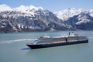 A cruise ship sailing through Alaska's glacier surrounded waters