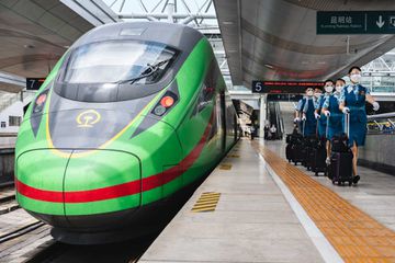 Employees walk past a train in a station in China.