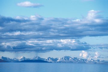 Snow capped mountains along the edge of vast blue lake in Mongolia 