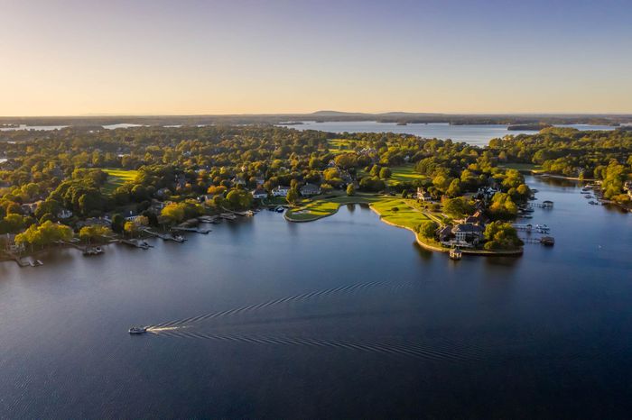 Landscape shot of aerial view of Lake Norman in the vicinity of Ramsey Creek Park, trees and community in background during daytime