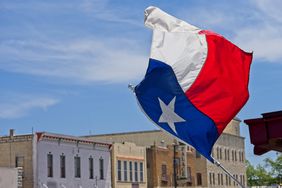 The Texas state flag flies over downtown Main street Fredericksburg Texas.