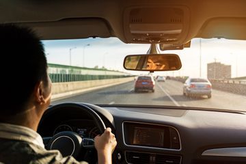 A man driving car on a bridge/highway