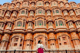 A woman in front of the Palace of the Winds Hawa Mahal.