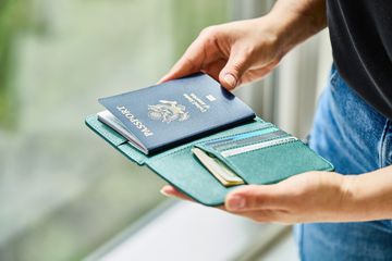 A person holding a passport in a passport holder