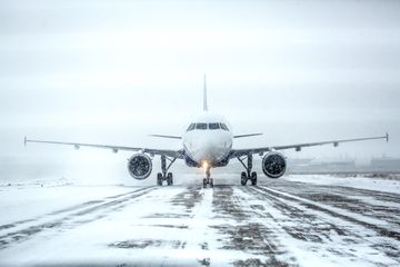 A passenger plane on a runway in a blizzard