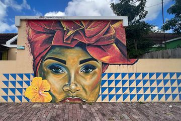 A street art mural of a female presenting person in Curaçao