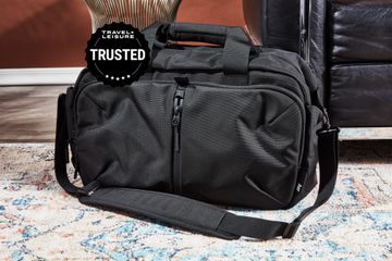 An Aer Travel Weekender bag sitting on a carpet