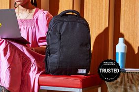 A person on a laptop next to the Solo Re:Define Backpack