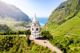Aerial view of clock tower of Nossa Senhora de Fatima chapel in the green valley, Sao Vicente, Madeira island, Portugal