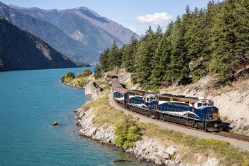 Exterior of the train going around a curve by water and mountains
