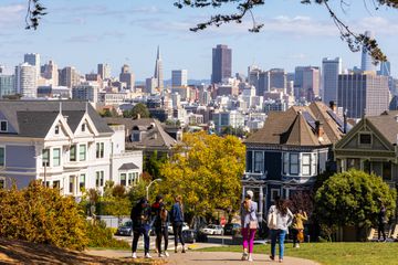 People walk on a path near homes in San Francisco's Alamo Square.