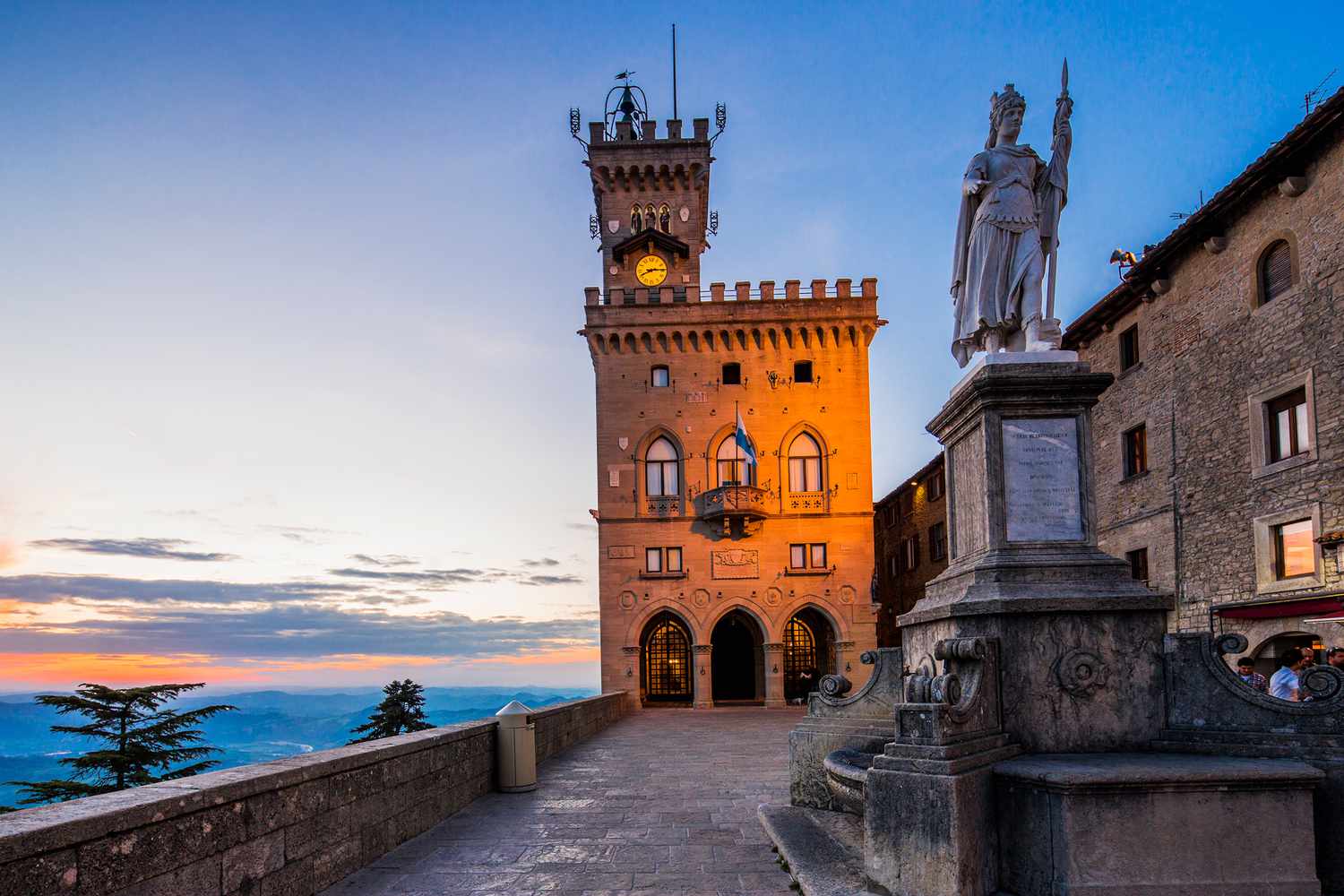 The Palazzo Pubblico (Public Palace, Town Hall) and the Statua della LibertÃ  (Statue of Liberty) by Stefano Galletti (1876) at twilight